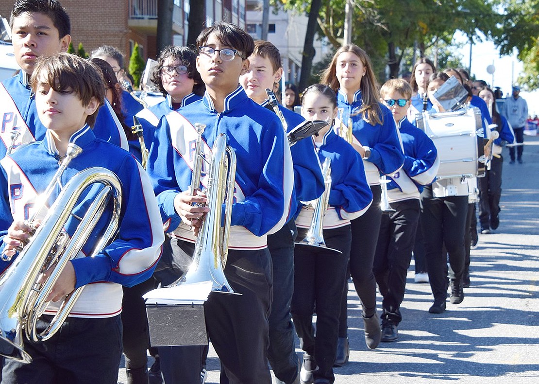 In line and ready to shine, Port Chester Middle School band students strut in synchrony, waiting for directions to pick up their horns and play.