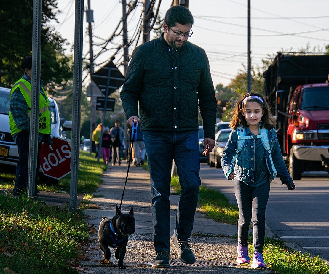 First-grader Annabelle Damle walks with her father Ajay and their dog Remy to King Street Elementary School for another day of classes.