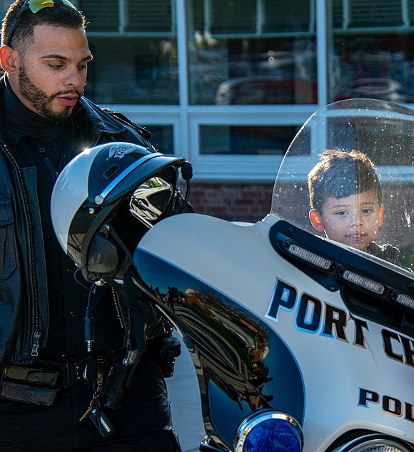 Chase Krzeminski, son of recently promoted Port Chester Police Lieutenant Christopher Krzeminski, sits on a department motorcycle as Police Officer David Arroyo watches him. The 4-year-old isn’t old enough to be a student at King Street Elementary School, but he’ll attend in the future.