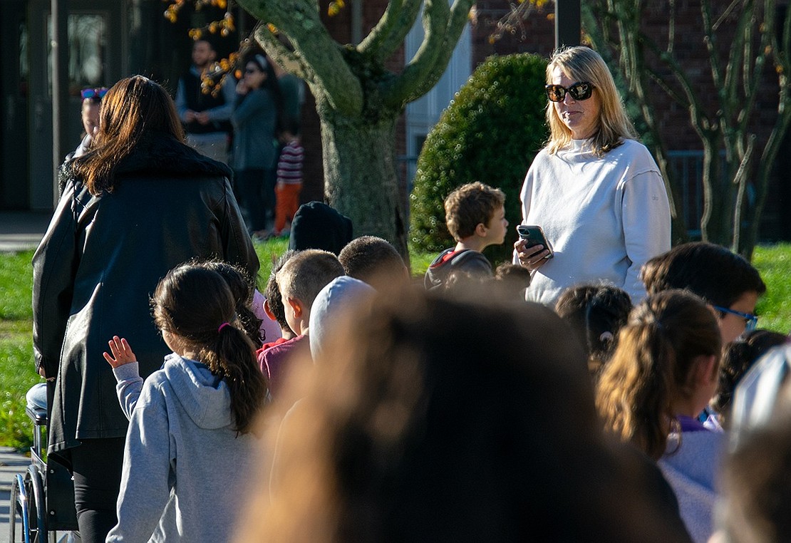 King Street Elementary School parent Jody Helmle watches the parade of students who walk through the parking lot for Walk to School Day. Her fifth-grade son Evan is one of those in the crowd.