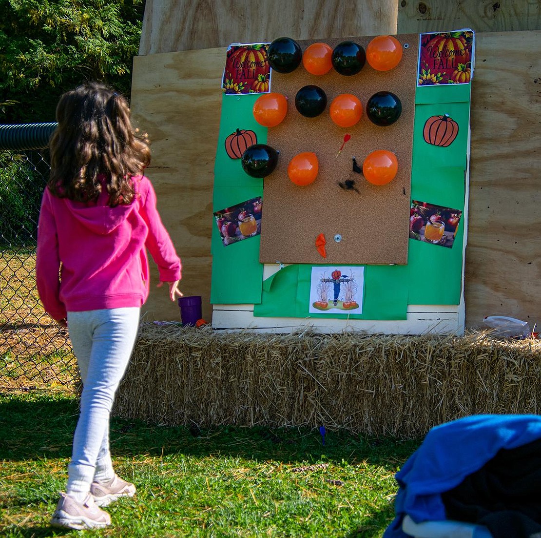 Alessandra Herrera aims, fires, and pierces a balloon on a dart board. It took the Ridge Street Elementary School second-grader a few tries, but she didn’t give up.