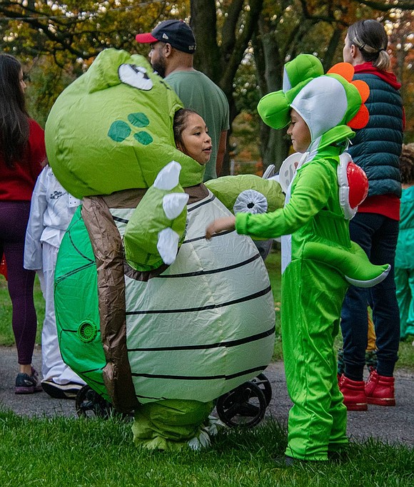 Park Avenue Elementary School second-grader Mia Garcia wears a large blow-up turtle costume as she play-fights with King Street Elementary School second-grader Joseph Samano, who dresses as Yoshi.