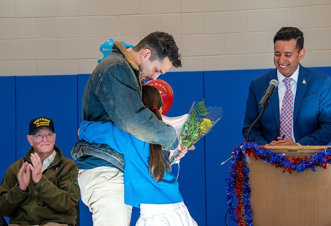 Woodland Avenue resident Christian Gimenez hugs his daughter Savannah, a fourth-grader at King Street Elementary School, as other veterans clap and Principal Sam Ortiz smiles. The U.S. Marine Corps veteran nearly tears up in the moment as he’s honored during the school’s annual Veterans Day ceremony on Thursday, Nov. 10.