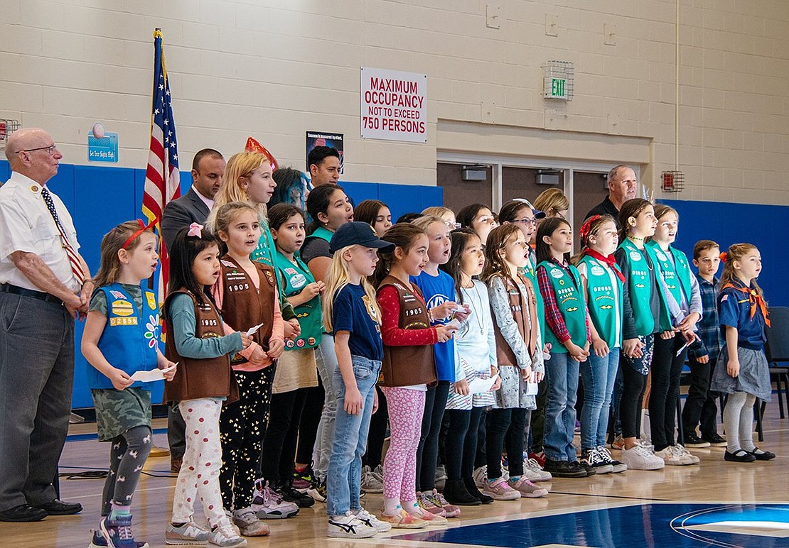 Members of several local Girl Scout troops sing “God Bless America” in observance of Veterans Day at King Street Elementary School. Some of the girls stepped up and became one of the veteran’s escorts, as he no longer had family attending the school.