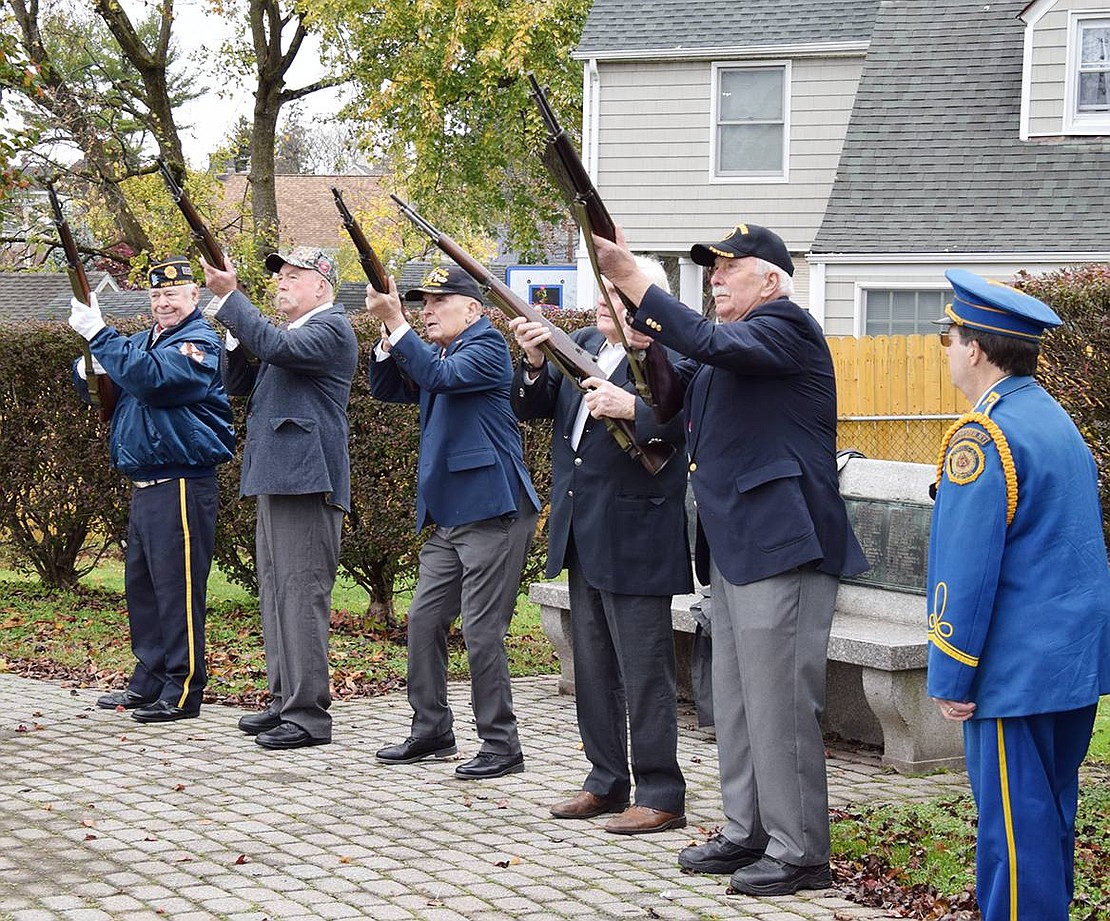 American Legion Firing Squad members, from left, Kenny Neilson, William Sullivan, Jr., Tommy Giorgi, Richard Cuddy and Vinny Lyons fire shots to honor all veterans while bugler Anthony Bubbico, Jr. of the Port Chester American Legion Band stands at right waiting to play Taps in memory of those veterans who have died.