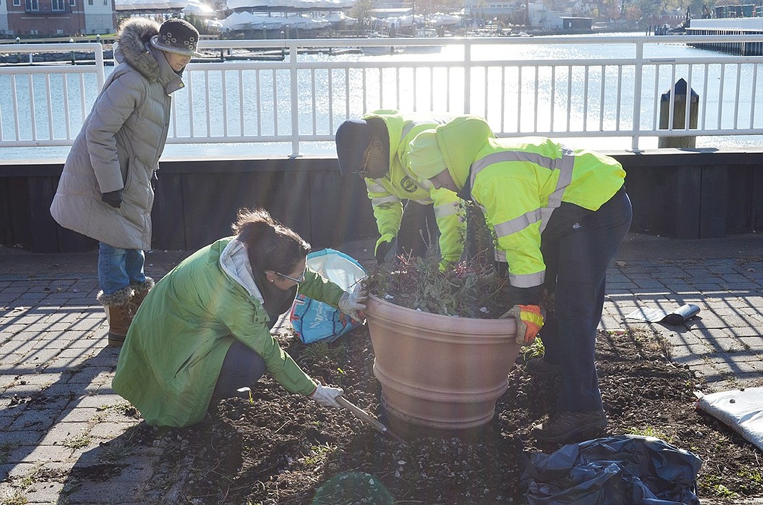 Arianna Christopher, chairman of the Port Chester Beautification Commission, works with Port Chester Parks Department employees Kenny Redd and PJ Cambriello to reposition one of the large flowerpots along the Byram River promenade as part of the Village’s Community Cleanup Day. The blustery weather kept volunteers to a minimum.