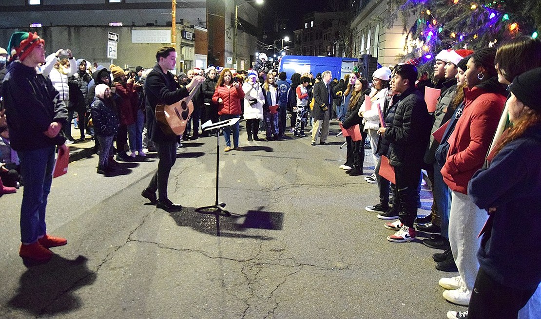 Teacher Jonathan Pereira plays guitar while members of Port Chester Sound, Port Chester High School’s a cappella group, sing holiday melodies.