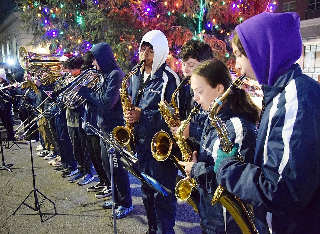 Members of the Port Chester High School Band play “Carol of the Bells” in front of the lit Christmas tree.