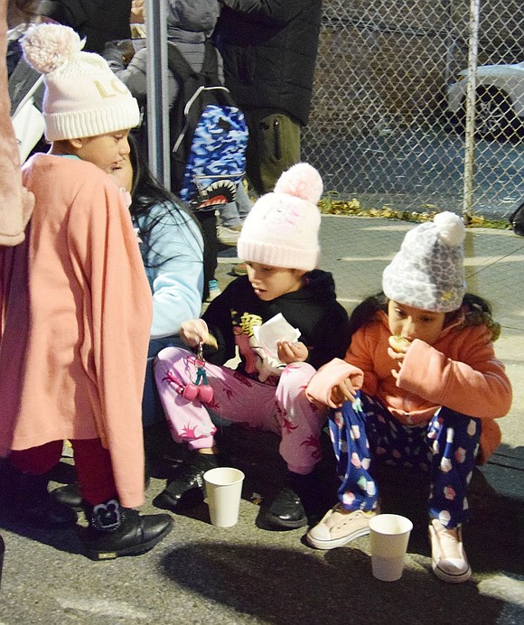 Allison Elliott, 6, and Yasuri Henriquez, 5, of King Street enjoy the cookies and hot chocolate provided by the Salvation Army.