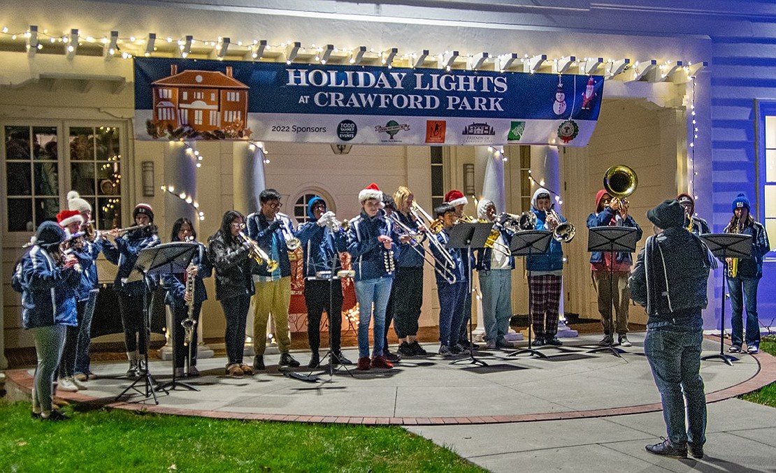 Student musicians from Port Chester High School perform holiday music to a crowd of eager listeners behind the Crawford Mansion Community Center. Some of the songs highlighted specific sections of the band—one was played solely by a choir of flutes.