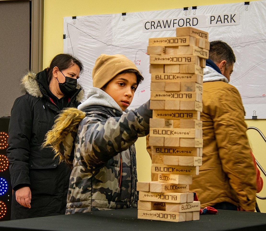 Fabio Garcia, 11, tries his hand at Jenga, set up on the second floor of the Crawford Mansion Community Center along with several other carnival-style games. The Glen Avenue resident doesn’t make a single mistake as he pulls blocks from the tower.