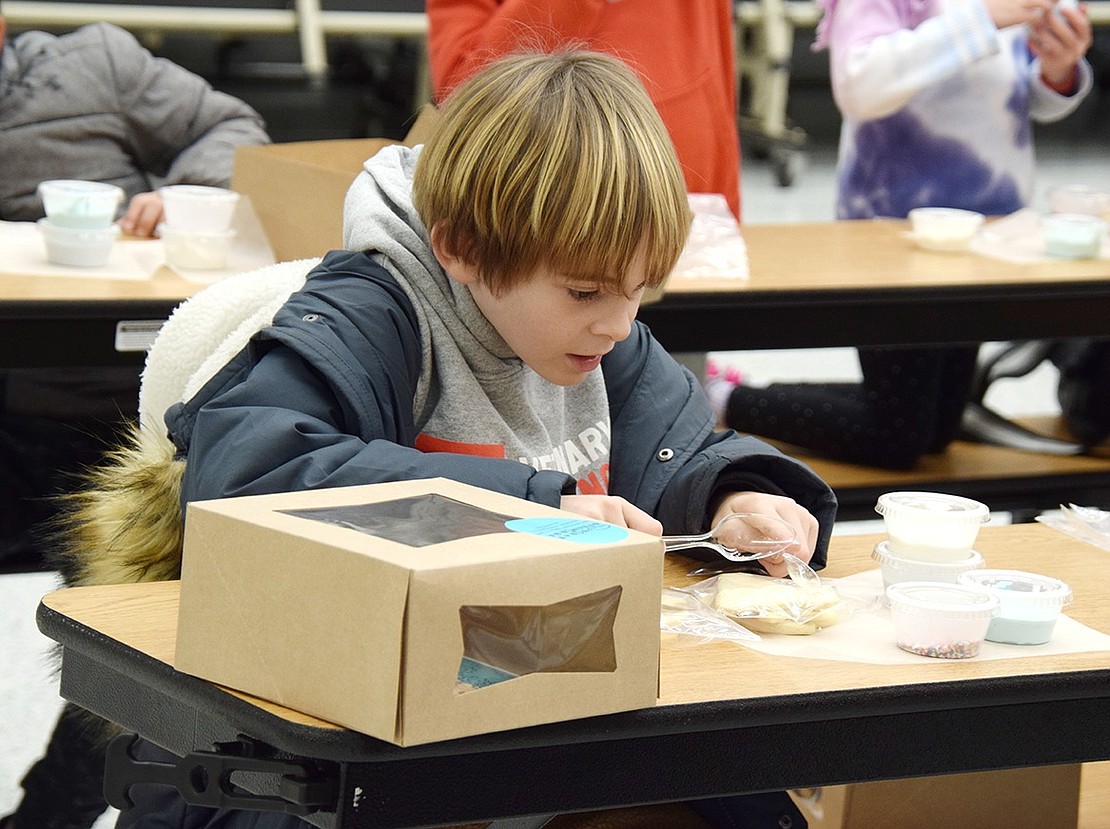 Embodying the “Little Drummer Boy,” first-grader Maddox Emott uses his spoons to dish out beats on anything in sight, at first seemingly more interested in making music than pretty cookies.