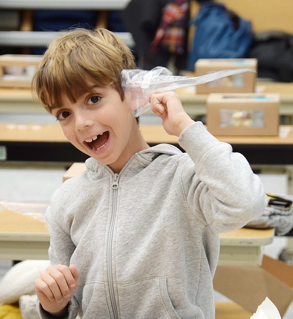 Before getting to work on his cookie art, first-grader Kaden Firestone takes a good listen to his piping bag to find out if it has any secret decorating tips to share.