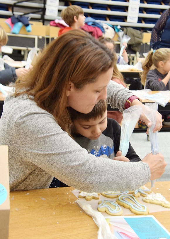 The magic of the holidays feels stronger when family is around. Brandy Beltas cuddles up with her first-grade son George as they work together on their decorating.