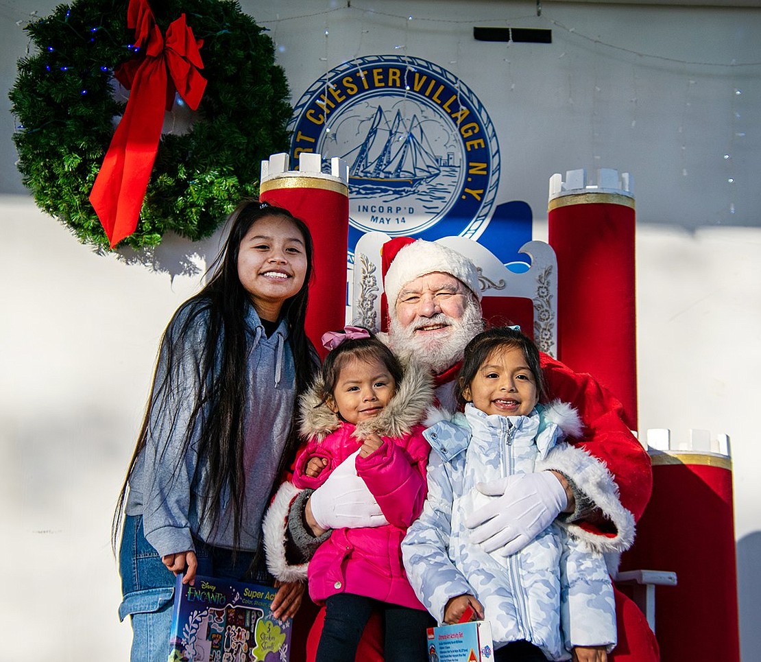 Port Chester High School sophomore Dayana Soto (left) poses with Valentina, 3, and Flavia Aparcana, a King Street Elementary School kindergartener, for pictures with Santa, who goes by Charlie Sacco most of the year.