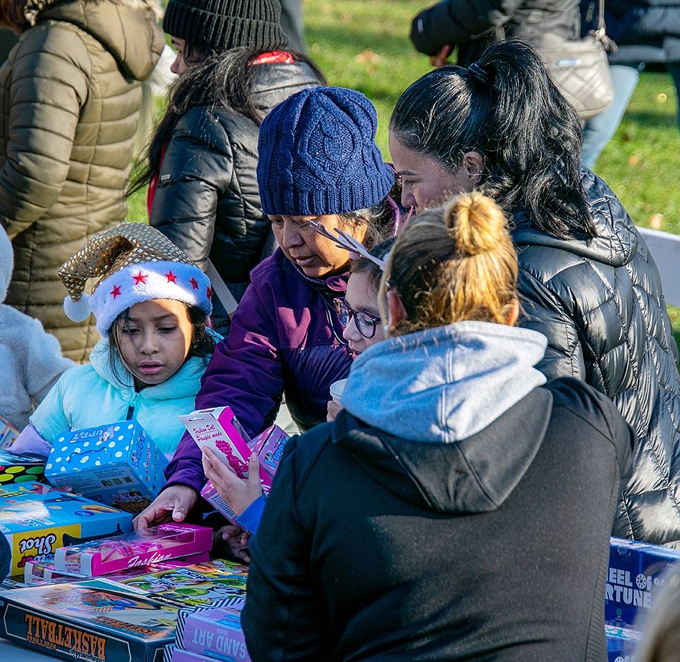 John F. Kennedy Elementary School second-graders Harper Gonzalez (left) and Dana Mejia pick out toys with their mothers’ help—gifts given to the community children by the Village of Port Chester.