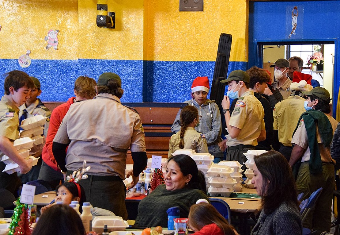 Elves aren’t Santa’s only helpers: The BSA Scouts have been known to assist him from time to time, too. On Saturday, they help by cleaning up the breakfast foods that families feasted on at the event.