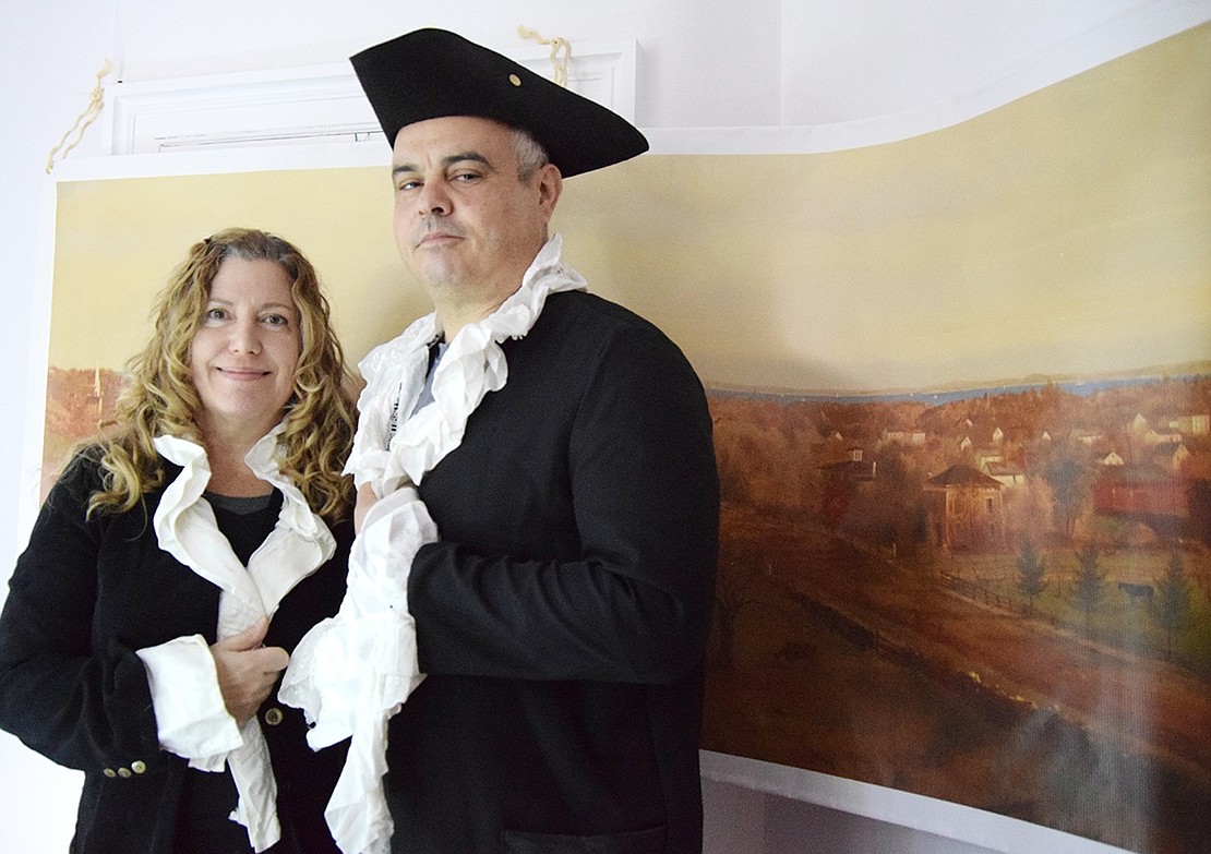 Lael Porcelli and Lou Russo of Hobart Avenue dress up in Colonial garb and stand in front of a banner of an 1871 painting of Westchester Avenue in Port Chester looking down to the Byram River and the Sound by Charles Themmen. The original painting hangs in the Port Chester-Rye Brook Public Library. The Russos were among many who tried on period costumes at the Port Chester Historical Society’s WinterFest on Saturday afternoon, Dec. 17 at the Bush Lyon Homestead at 479 King St.