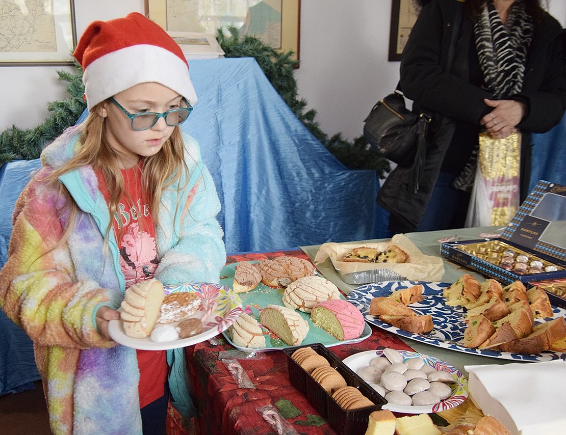 Arianna Butkiewicz, 9, of Locust Avenue fills her plate with a selection of goodies from countries around the world which were available at WinterFest.