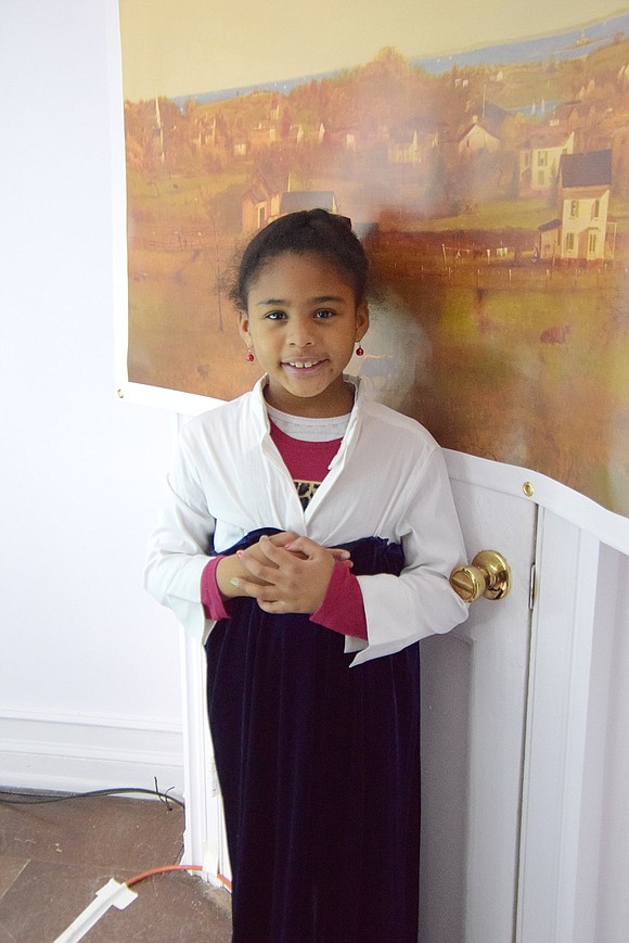 Donning a period dress, Savannah Jones, 7, of Seymour Road is as pretty as the replica of the historic painting of Port Chester behind her.