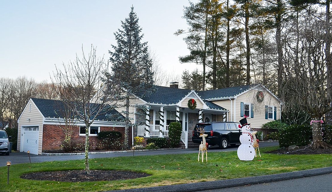 Keeping it simple, the residents of 7 Bobbie Ln. chose to decorate their yard with a light-up reindeer, a snowman and lots of strings of white lights. A few wreaths and strands of garland spiral around the columns on the house’s front stoop, providing a touch of green to the layout.