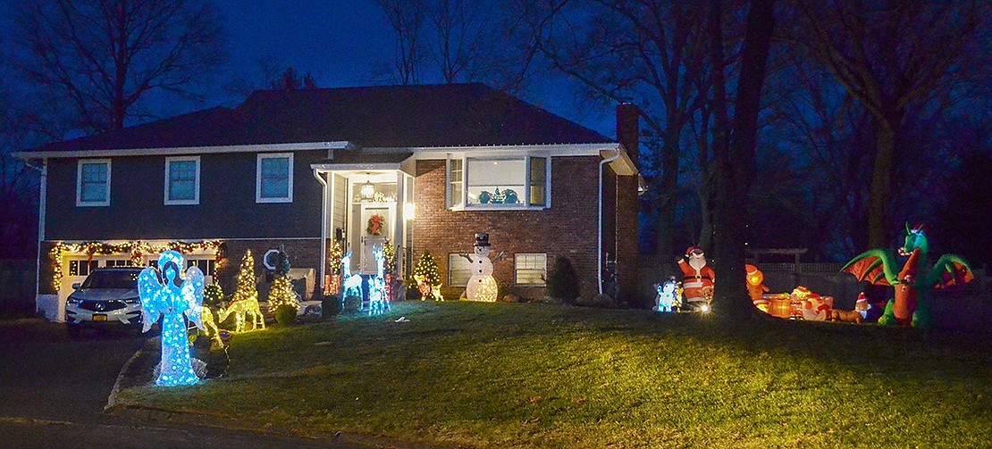 A mighty blow-up dragon roars on the side of 33 Country Ridge Dr., flanked by Santa and his sleigh. In the front of the home, in sharp contrast to the raging beast, a softly lit angel and a few reindeer line the walkway to the front door.