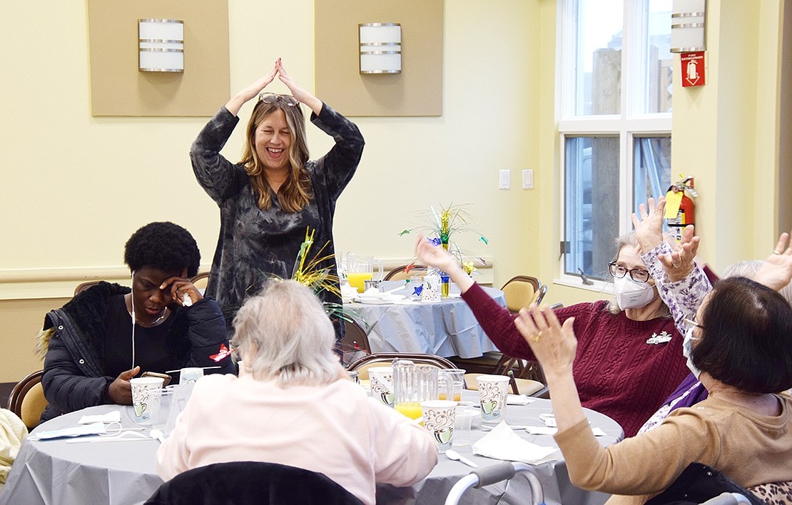 Amping up the energy, Rye Brook Senior Center Director Liz Rotfeld, a Port Chester resident, leads a table of partygoers through “YMCA” choreography.