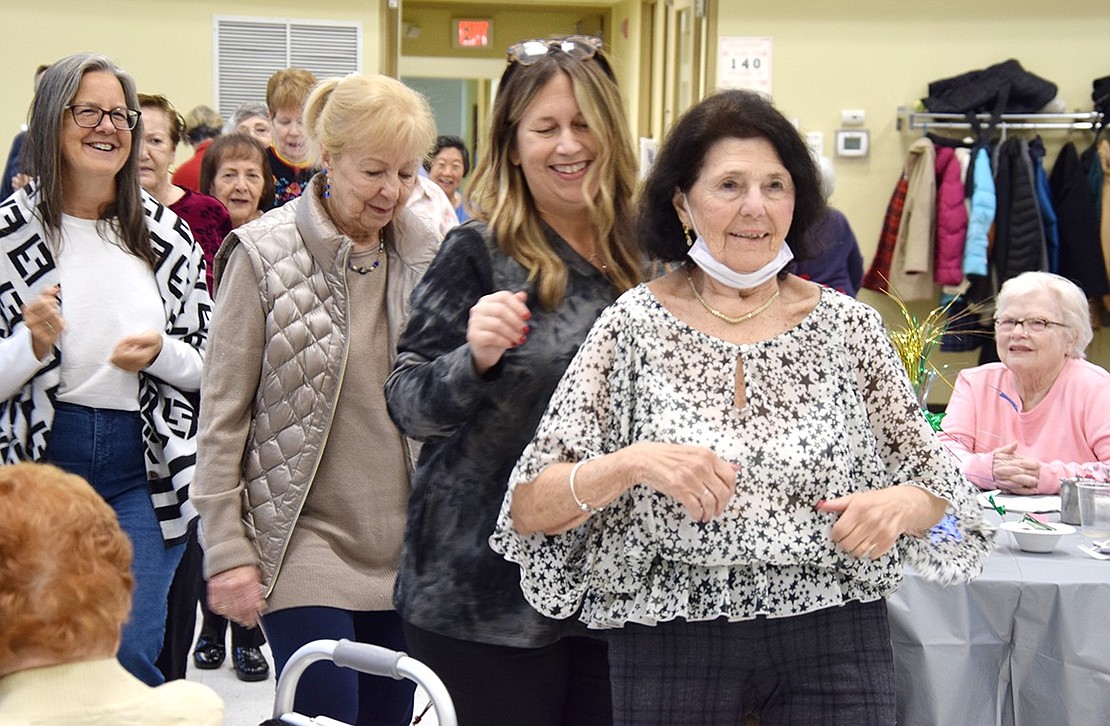 At 91 years old, Avon Circle resident Gloria Mangiamele cha-chas as she leads a growing conga line around the Rye Brook Senior Center dining room.