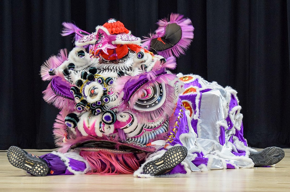 The lion sits on the stage, ready to spring up and dance away bad luck for the Lunar New Year.