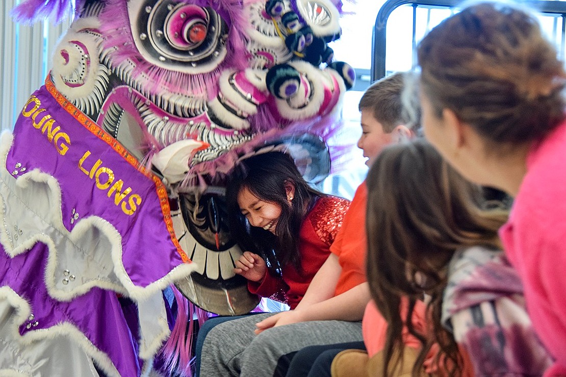 Natalia Samela, a third-grader, gets eaten by the lion. She laughs as the furry beast wraps its jaws around her head.