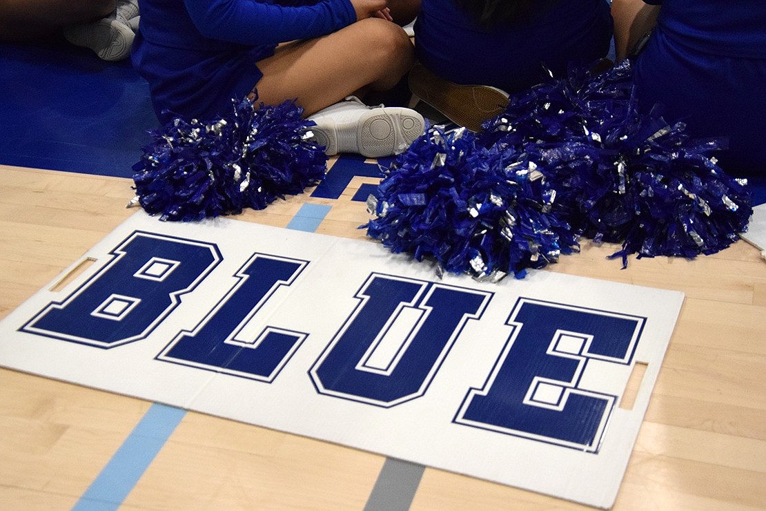 Port Chester Rams bleed blue and white! Cheerleading gear lays on the gymnasium floor as stunters watch other school teams perform.