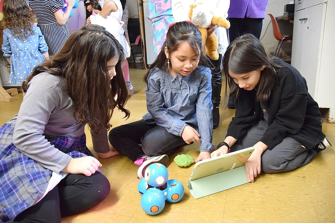 Showing off their coding abilities, Park Avenue School fourth-grader Amelia Zuccarelli, Park Avenue School second-grader Mia Carranza and King Street School fourth-grader Emma Ramos send control messages to a robot with an iPad.