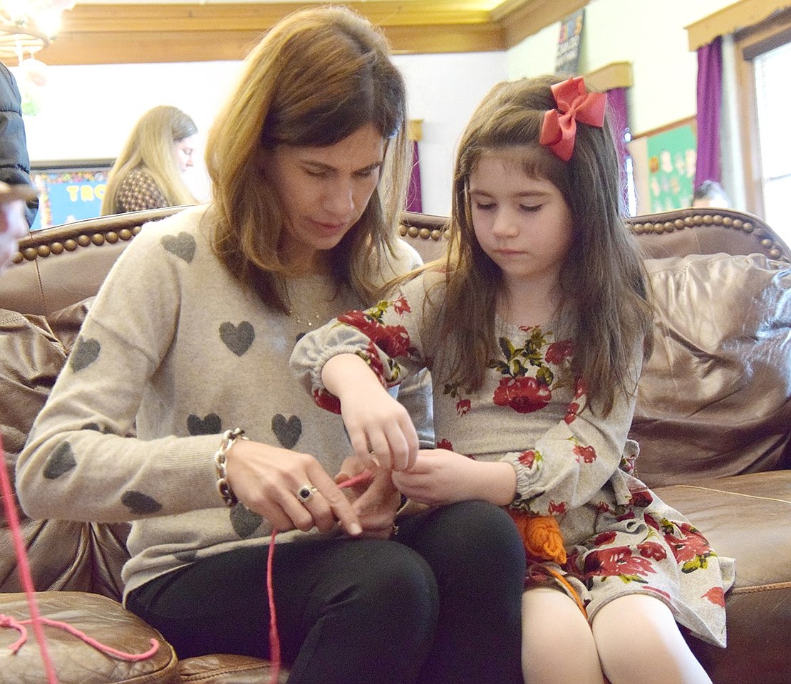 Making memories with some mother-daughter bonding, Mamaroneck resident Anita Casey and her 6-year-old daughter Lucy sit side-by-side to work on a yarn craft together.