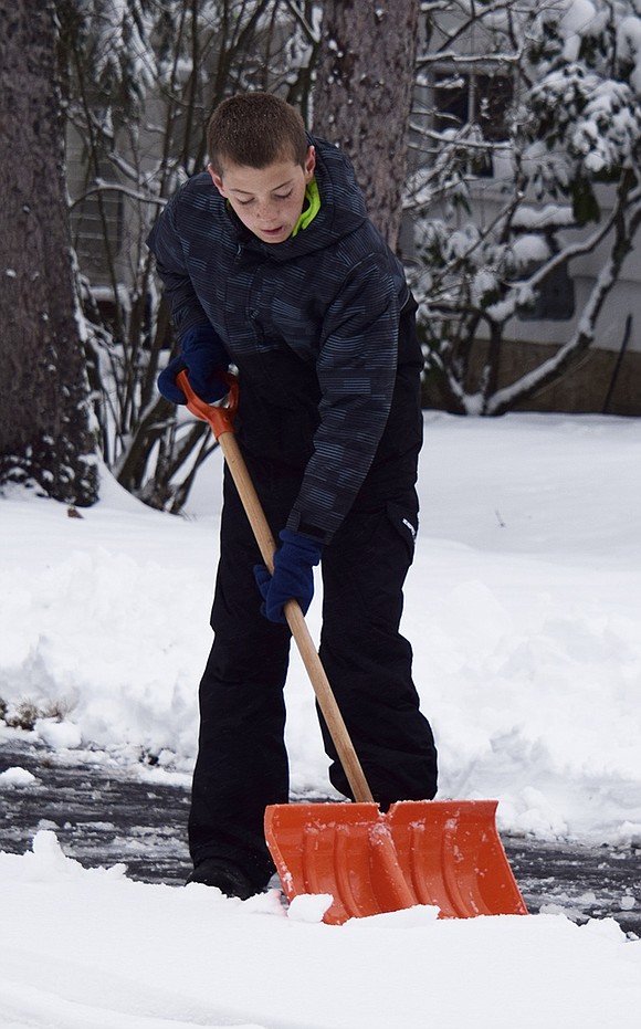 Thirteen-year-old Evan Maniscalco of Loch Lane shovels the driveway of family friend Frank Liotti at 24 Beechwood Blvd. Tuesday morning. His twin brother Thomas worked alongside him.